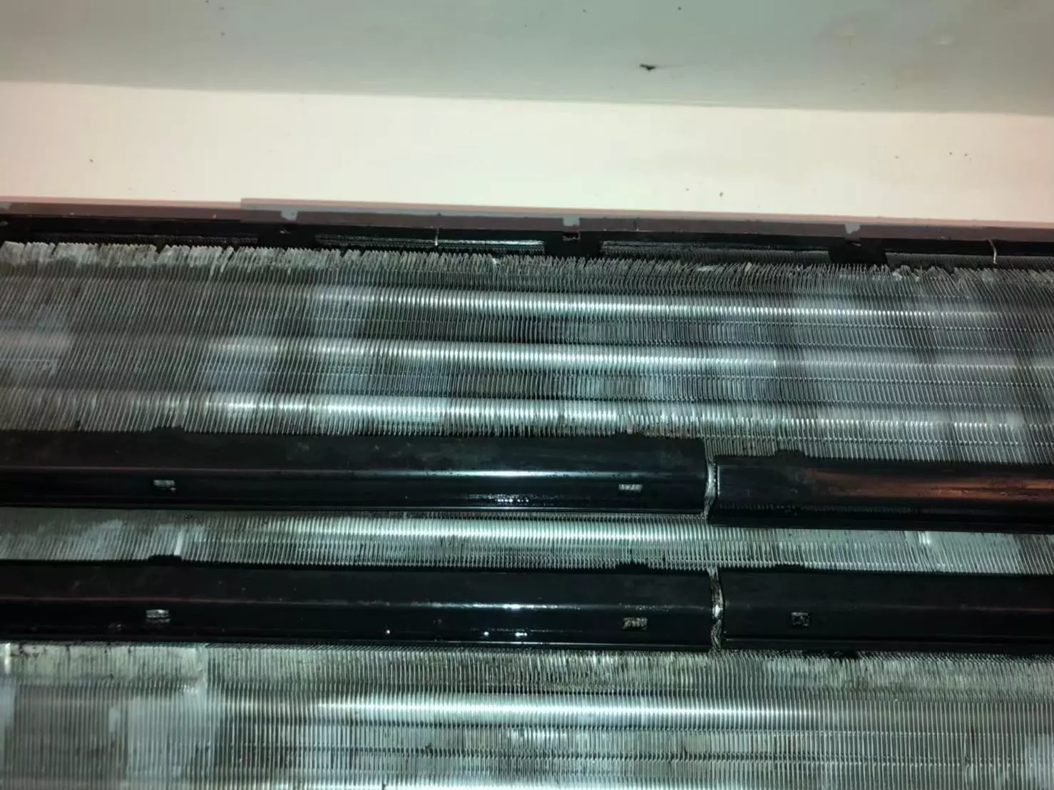 分離式冷氣內部打開後的狀況，內部零件可見明顯髒污與發霉情形，為常見冷氣清潔前畫面。